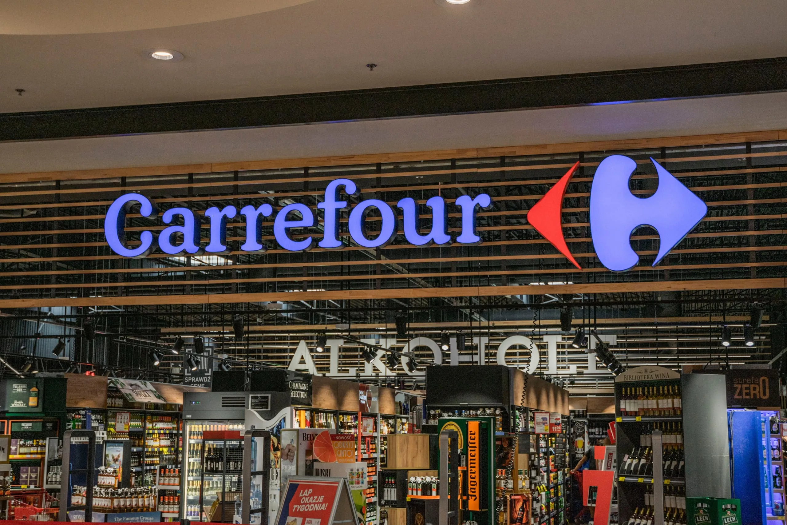 Intérieur d'un supermarché Carrefour avec ses rayons de boissons et ses espaces de vente