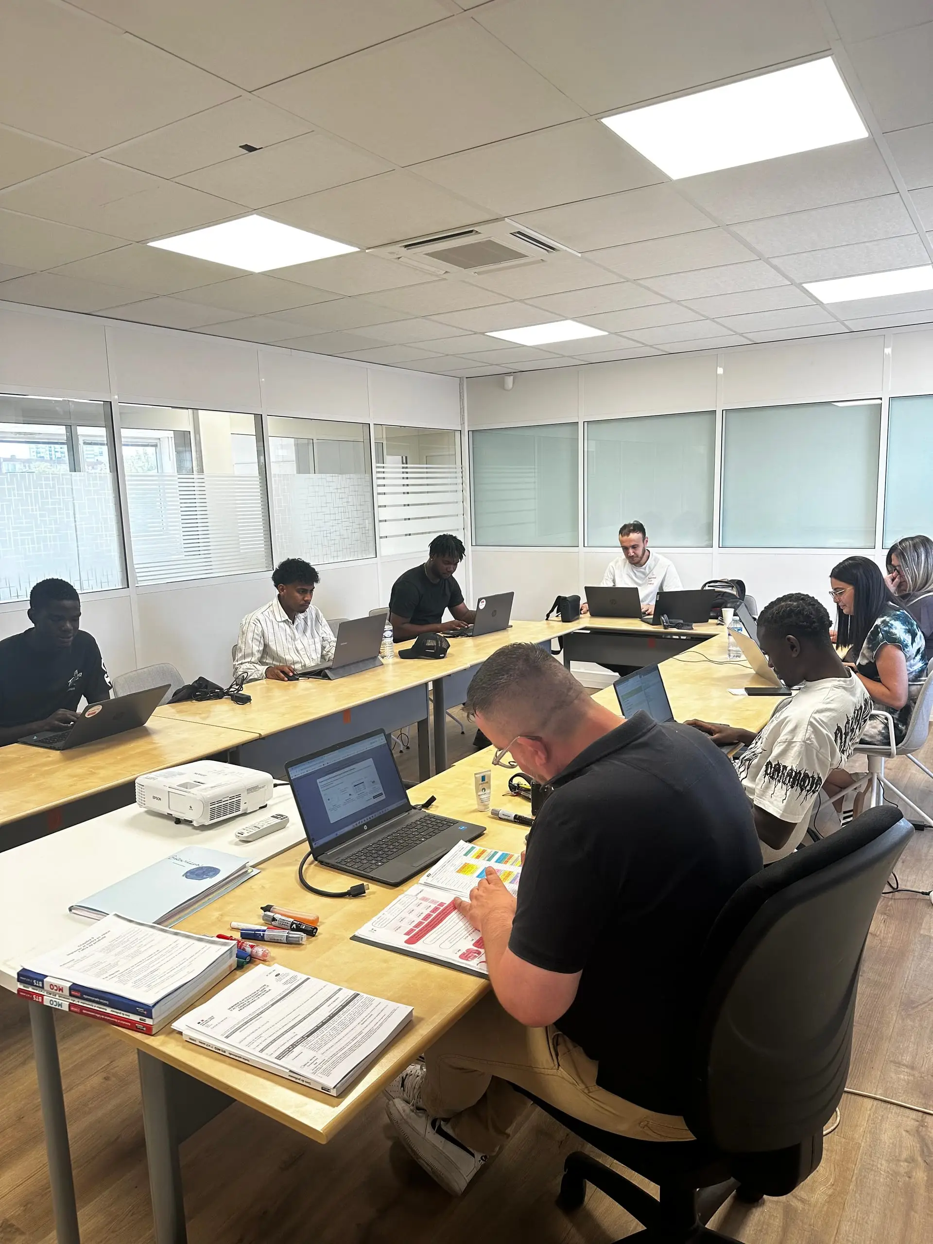 Apprenants et formateur du CFA Paedagogia travaillant autour de tables en U